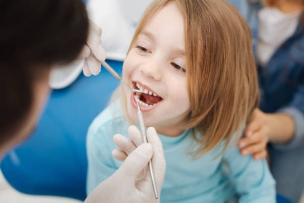 Not scary at all. Adorable entrusted brave kid being unafraid of the dentist while paying him regular visit for running a checkup