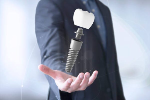 businessman hand withdental prosthesis